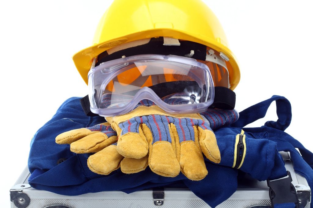 Construction outfit neatly folded with protective glasses, gloves, and helmet placed on top.